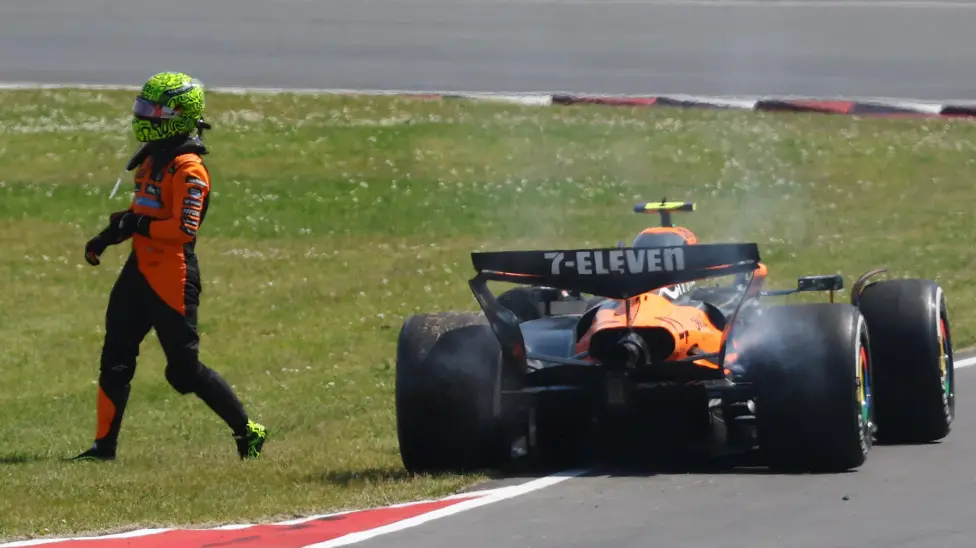 Lando Norris walks away from his damaged McLaren after after colliding with Oscar Piastri