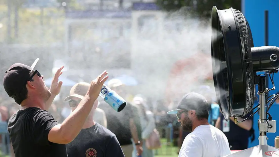 Mist tunnels, water machines and sun umbrellas are provided throughout Melbourne Park to help people cool down