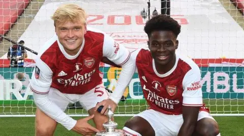 Matt Smith (left) and Bukayo Saka celebrate Arsenal's win over Chelsea at Wembley in 2020