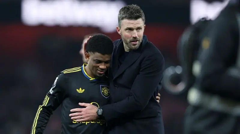 Manchester United winger Amad Diallo (left) with head coach Michael Carrick